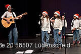 Eine Frau mit Gitarre und zwei Mädchen singen.