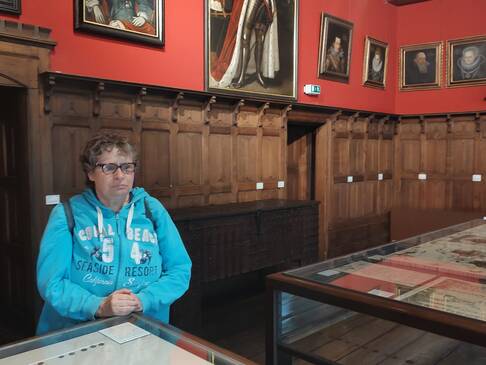 Eine Frau steht in einem Raum vor einer Wand mit Holzvertäflung