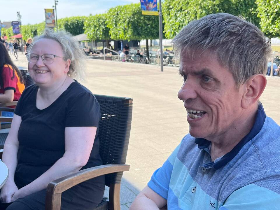 Ein Mann und eine Frau sitzen draussen.