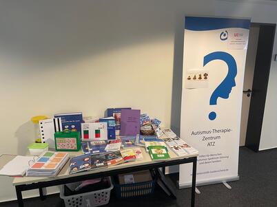 Der gesamte Infostand mit Broschüren auf dem Tisch und Roll up.