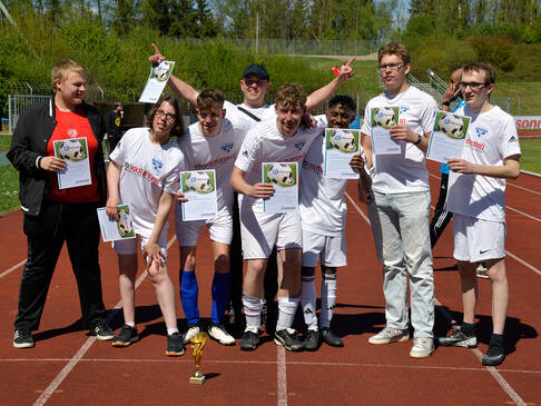 Ein Team in weißen Trikots jubelt.