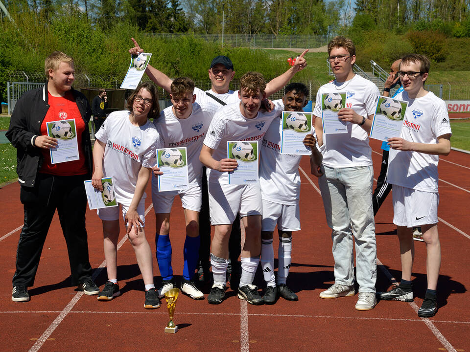 Ein Team in weißen Trikots jubelt.