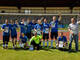 Ein Team mit blauen Trikots steht im Tor.