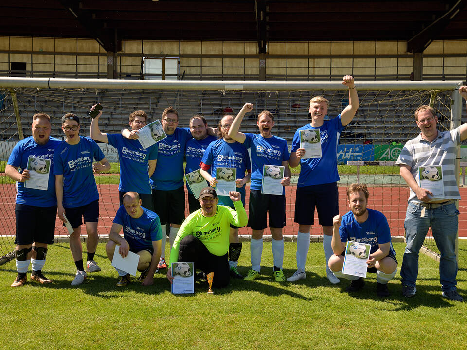 Ein Team mit blauen Trikots steht im Tor.
