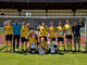Ein Team mit gelben Trikots steht im Tor.