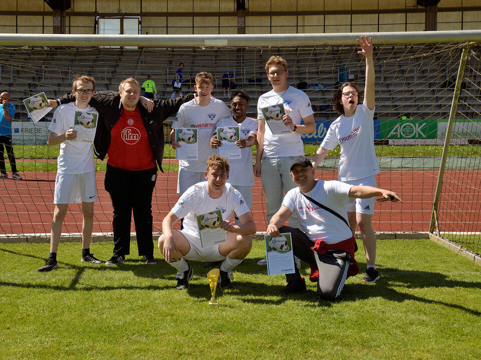 Ein Team in weißen Trikots steht im Tor.