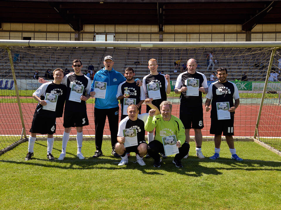 Ein Team mit dunklen Trikots steht im Tor.