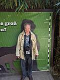 Ein Mann vor einem grünen Plakat mit einer Messtabelle.