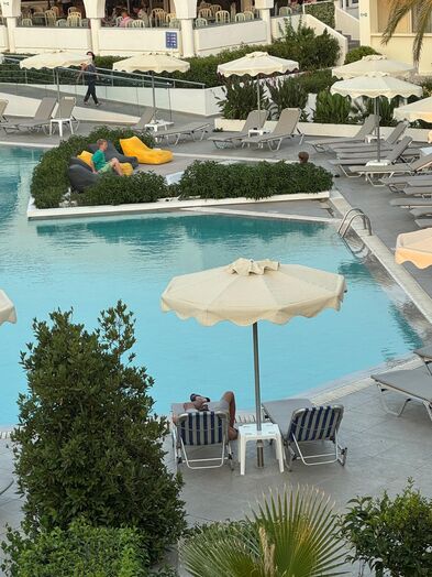 Viele Liegestühle um einen Pool  herum