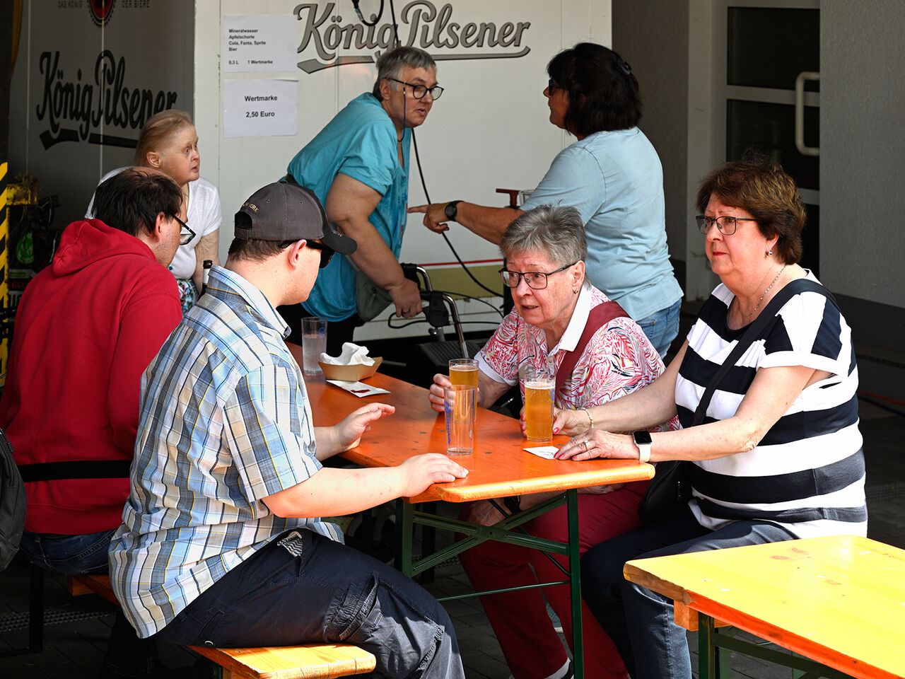 Menschen sitzen zusammen und haben Getränke.
