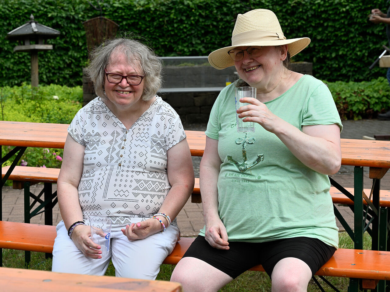 Zwei Frauen sitzen auf der Bank und lachen miteinander.