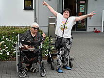 Zwei gut gelaunte Frauen vor einem Gebäude.
