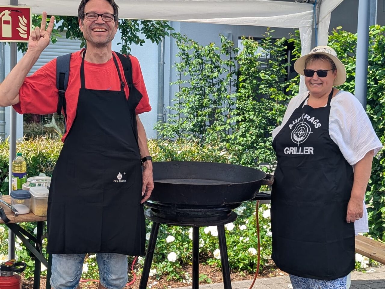 Zwei Personen neben einer sehr großen Pfanne.