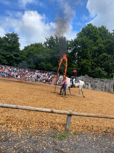 Eine Person reitet durch einen Feuerbogen.