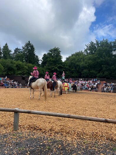 Schauspieler in rosafarbenen Outfitss mit Ponys.
