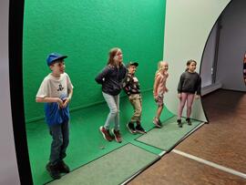 Kinder vor einer Greenscreen.