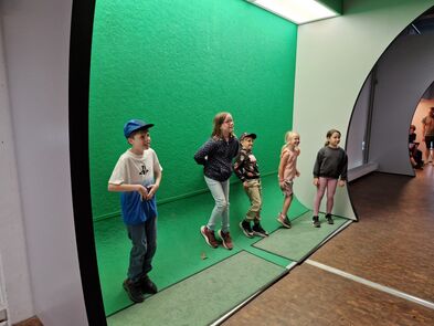 Kinder vor einer Greenscreen.