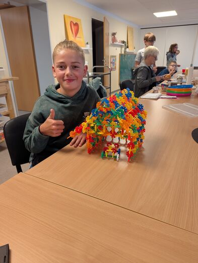 Ein Kind hat mit einem STeckspiel ein Haus gebaut.
