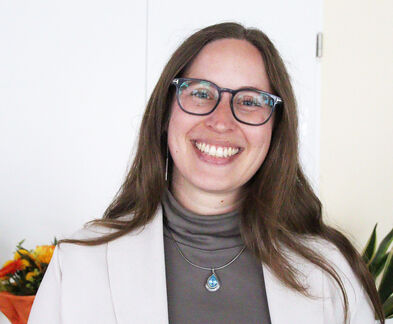 Eine Frau mit Brille lacht.,