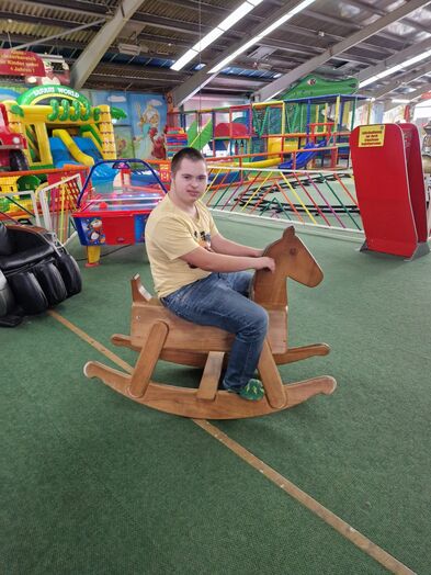 Ein Junge auf einem Schaukelpferd.