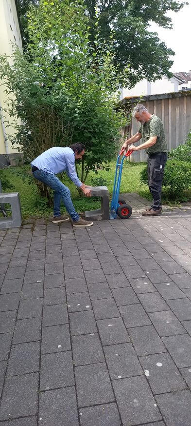 Ein schwerer Stein wird auf eine Sackkarre gehoben