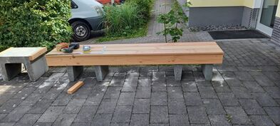 Auf den schweren Steinen werden Holzlatten befestigt.