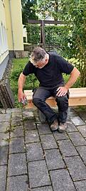 Ein Handwerker schleift das Holz ab.