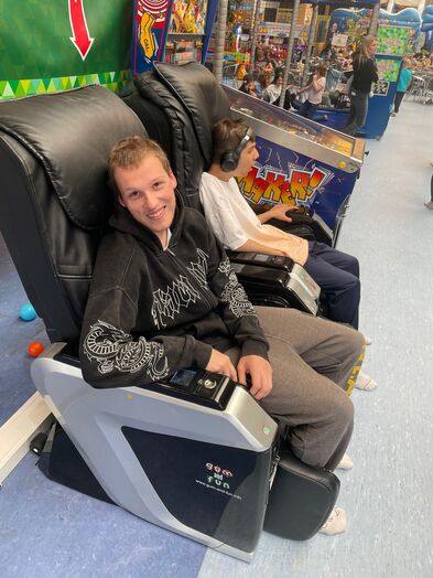 Ein junger Mann auf einem Massagesessel.