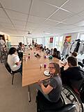 Viele Personen an einer langen Tafel.