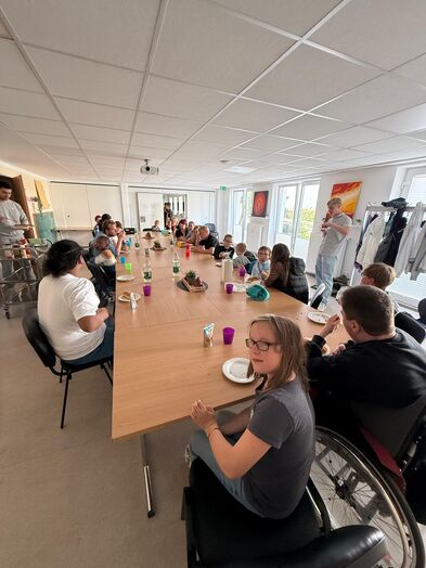 Viele Personen an einer langen Tafel.