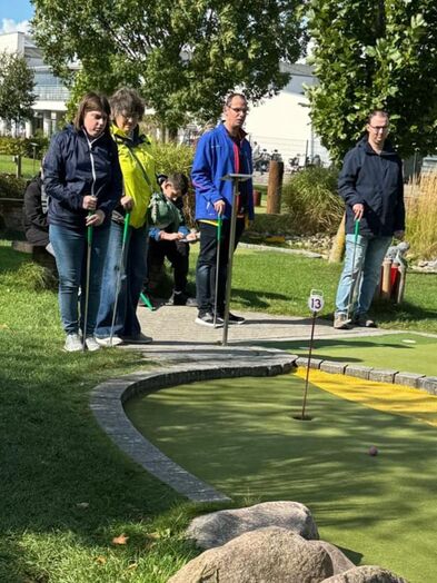 Mehrere Personen spielen Minigolf.