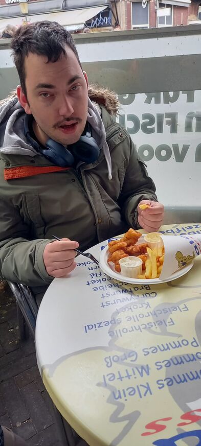 Ein Mann im Rollstuhl ist Fisch und Pommes