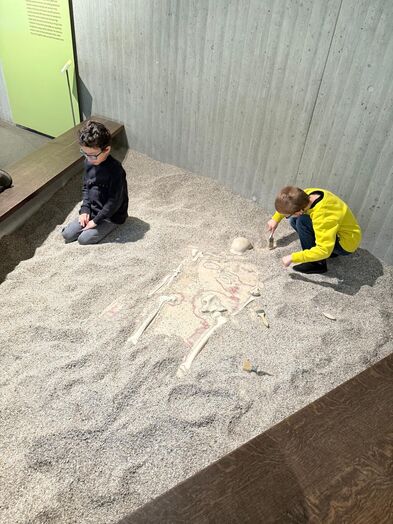Zwei Kinder in einer Ausgrabungsstätte.
