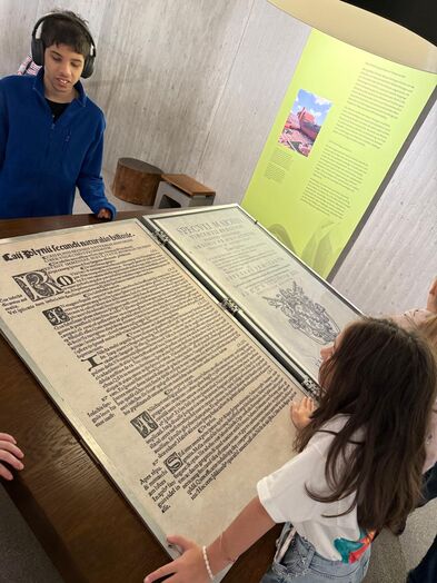 Kinder stehen an einer Informationstafel.