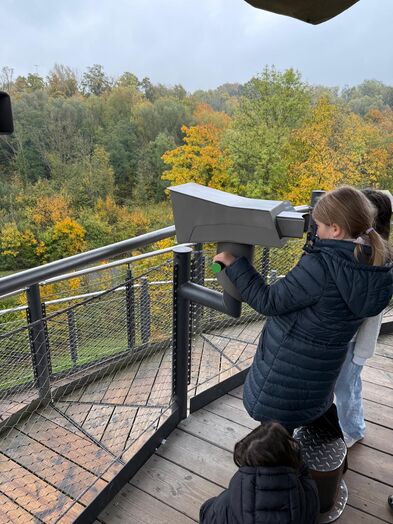 Ein Mädchen schaut durch ein Fernglas.