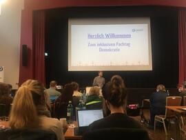 Auf einer großen Leinwand steht herzlich Willkommen zum Fachtag