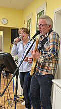 Ein Mann spielt Gitarre und singt, eine Frau singt mit.