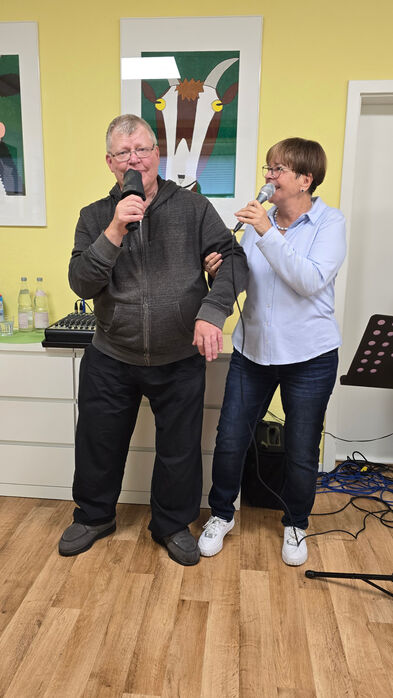 Ein Mann und eine Frau mit  Mikrofonen in der Hand.