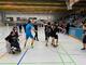 Spieler mit und ohne Hilfsmittel in einer Halle.