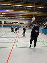 Spieler und Schiedsrichter in einer Halle.