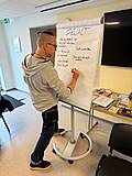 Eine Person schreibt am Flipchart.
