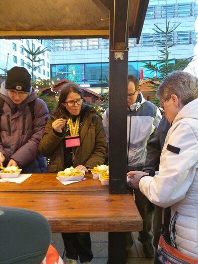 Mehrere Personen an einem Stehtisch draussen.