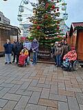 Gruppenfoto vor einem geschmückten Tannenbaum.