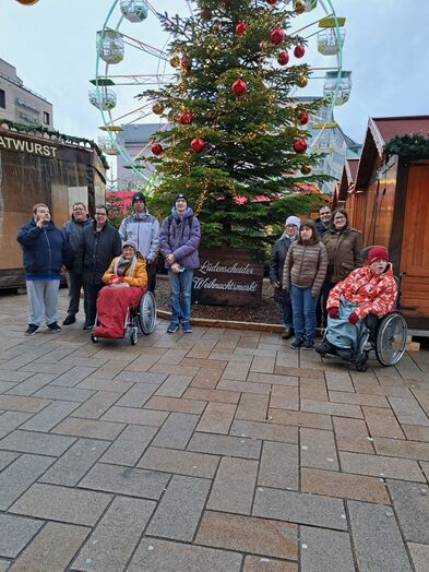 Gruppenfoto vor einem geschmückten Tannenbaum.