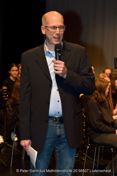 Sven Sieburg hält ein Mikrofon in der Hand.