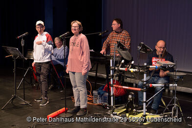Musiker mit und ohne Behinderung stehen auf der Bühne.