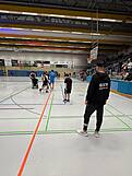 Spieler und Schiedsrichter in einer Halle.