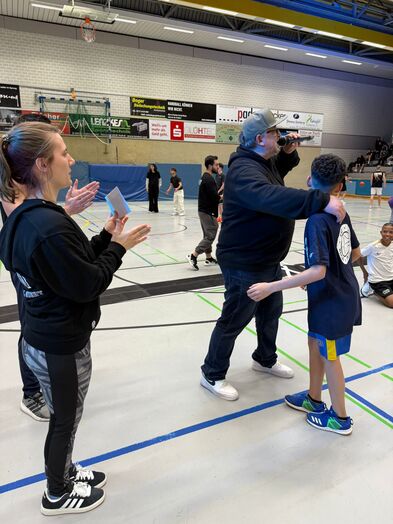 Der Moderator nimmt ein Kind in den Arm.