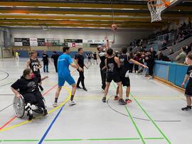 Spieler mit und ohne Hilfsmittel in einer Halle.