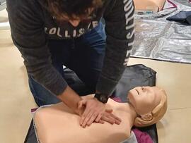 Eine Person übt an einer Puppe eine Herzdruckmassage.